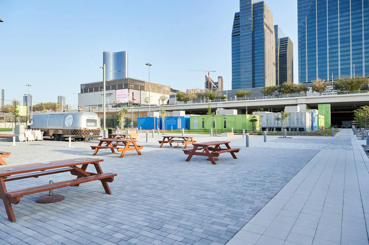 Rooftop terrace at Active Al Maryah Island Sports & Recreation in Abu Dhabi with wooden picnic tables and modern