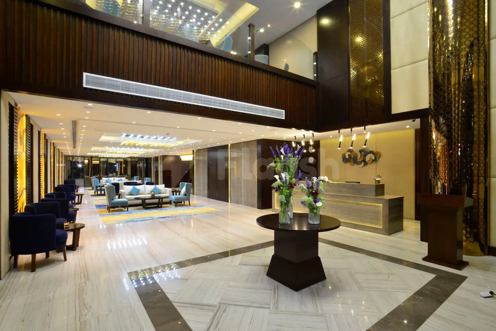 Entrance hall of Naviti By Warwick Dammam featuring a reception desk, marble floor with herringbone pattern, and dark