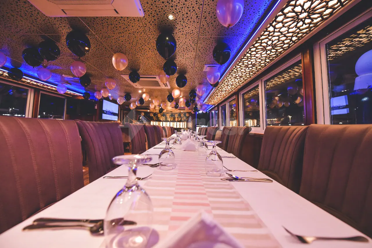 Long dining table set for an event at Royal Yacht Restaurant in Abu Dhabi, with balloons and patterned