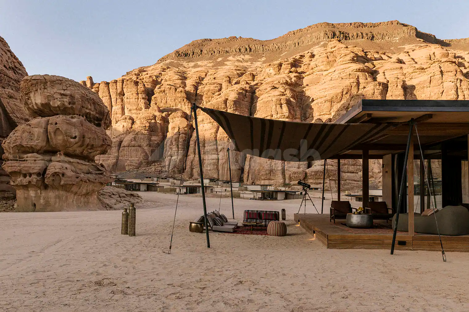 Terrace at Tama At Habitas AlUla in Al Ula featuring a wooden deck, striped canopy, and sand floor