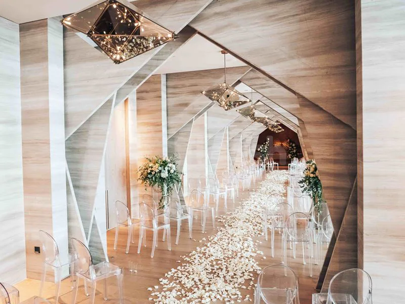 Ballroom at Beach By Five Beach Party Dubai featuring a white petal aisle and geometric ceiling light fixtures