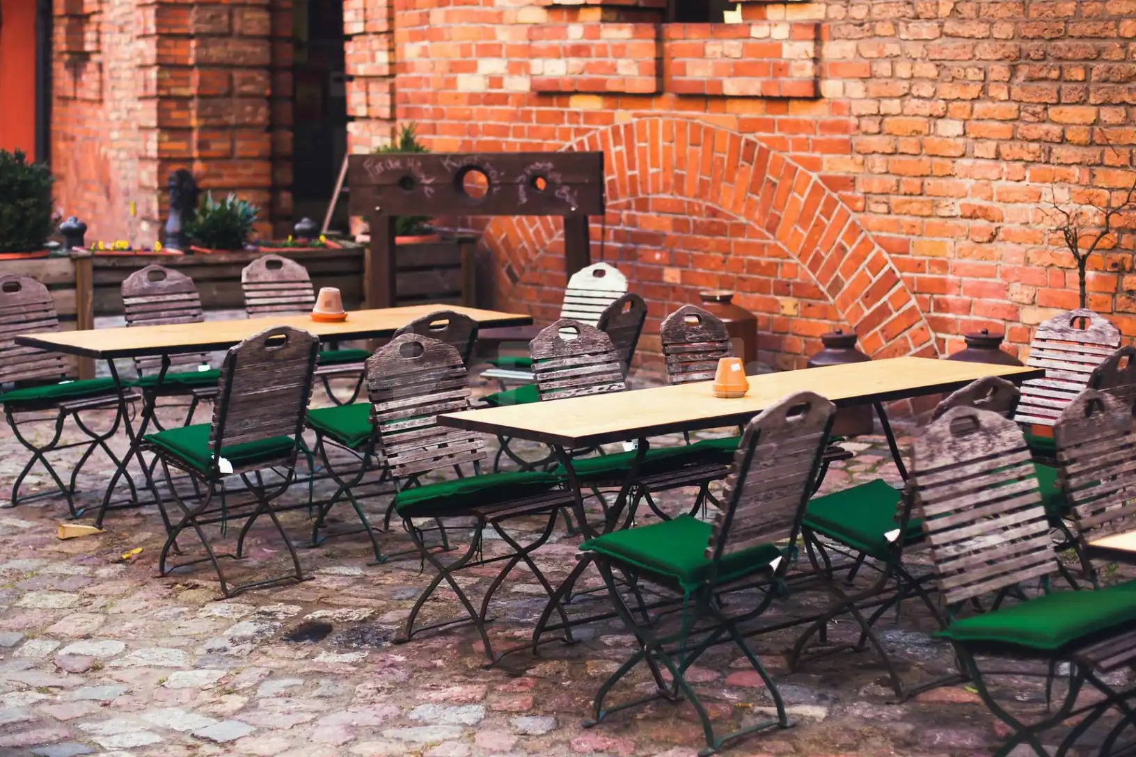 Terrace at Hoods Resto & Bar in Abu Dhabi featuring cobblestone flooring and a red brick wall