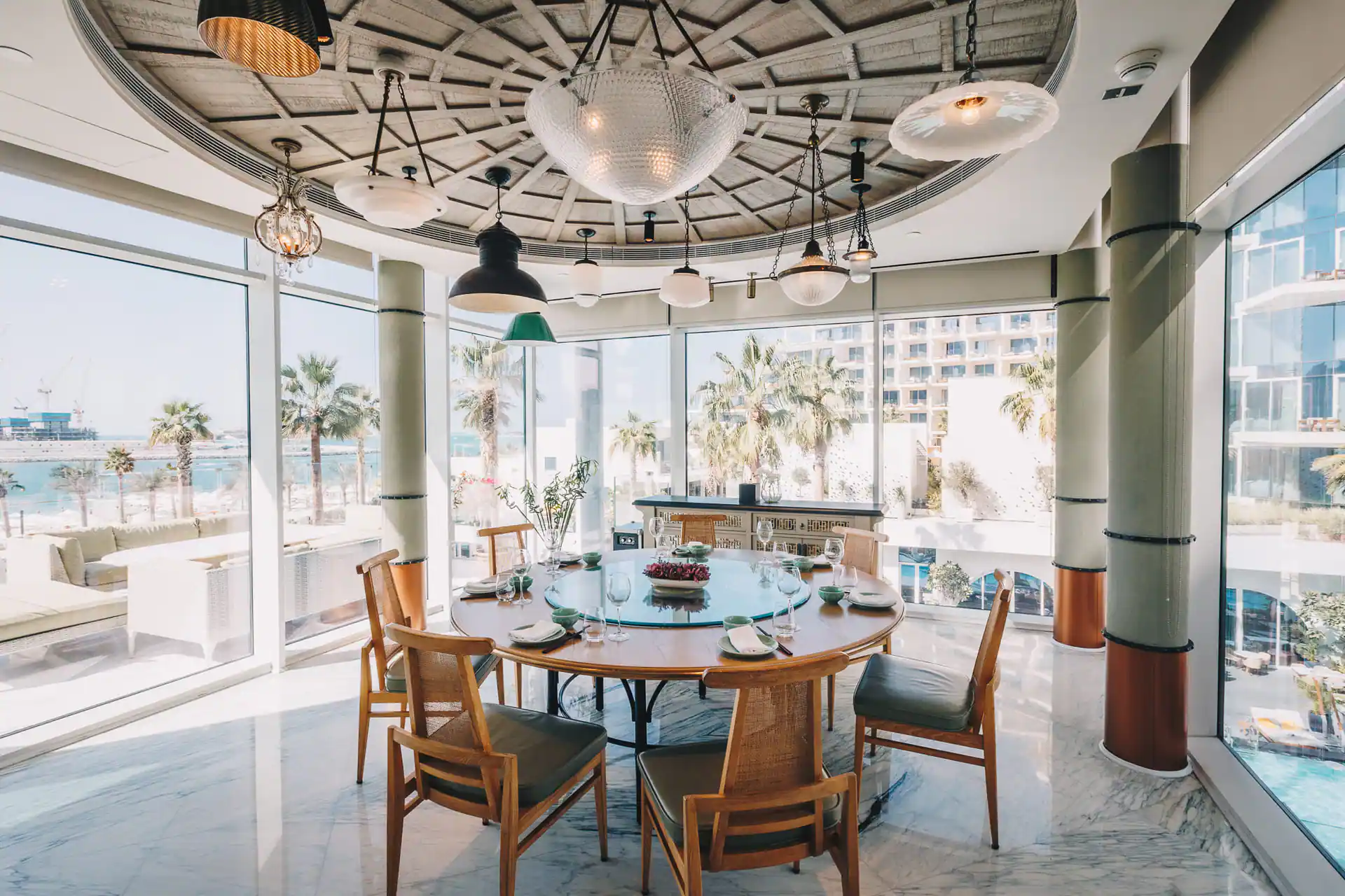 Round dining area at Beach By Five Beach Party Dubai with ocean and palm tree views