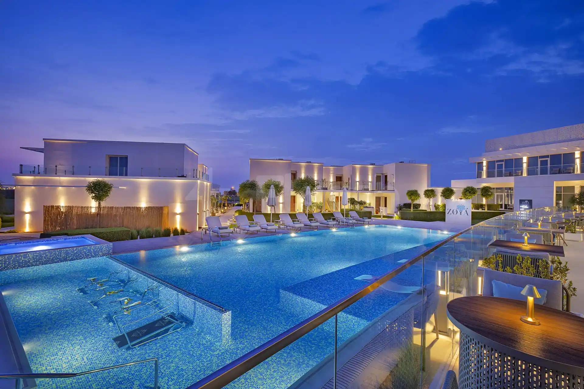 Rooftop terrace at Zoya Health & Well-Being Resort in Ajman with infinity pool and glass railing