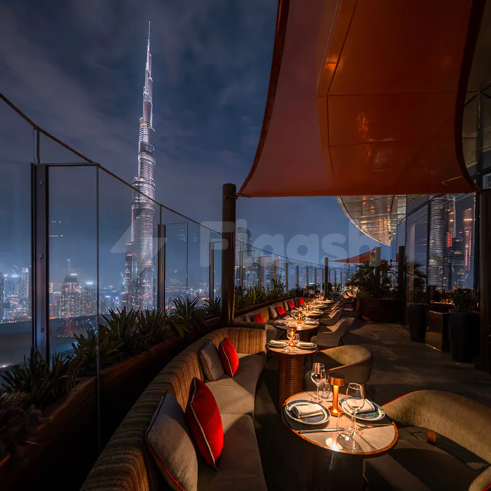 Rooftop terrace at CÉ LA VI Dubai featuring glass railings and a view of the illuminated Burj Khalifa