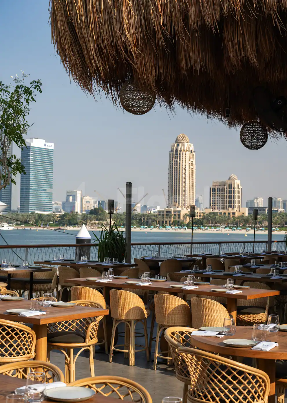Rooftop terrace at Bar du Port Abu Dhabi with thatched roof and hanging woven lanterns overlooking the waterfront