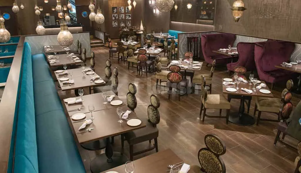 Ashas Restaurant Dubai dining area with teal booth seating and purple velvet armchairs under spherical glass pendant lighting