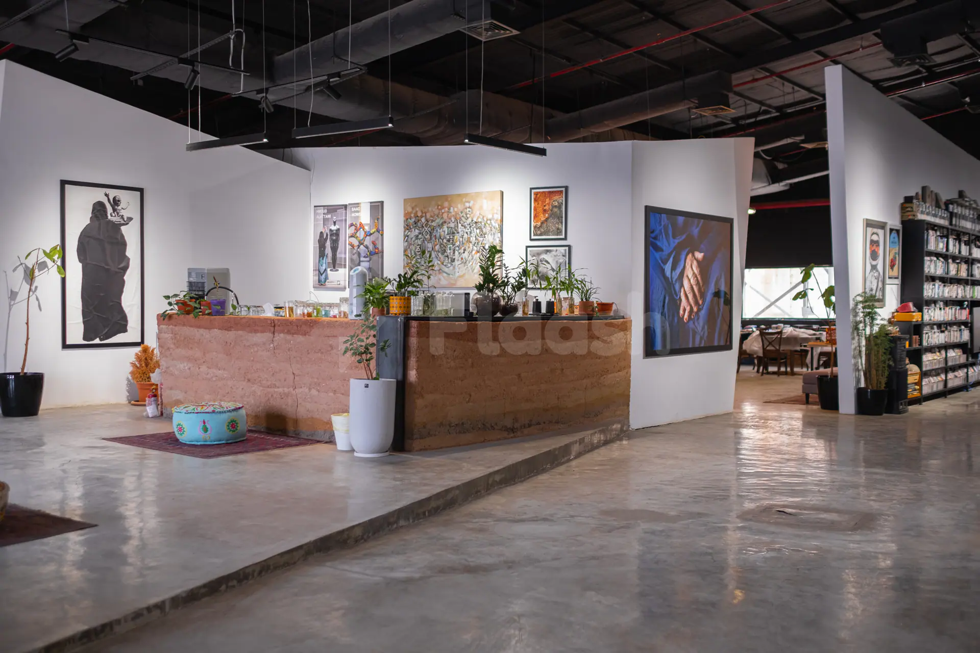 Entrance hall at Jax 01 Riyadh featuring a rammed earth reception counter and white walls with contemporary artwork