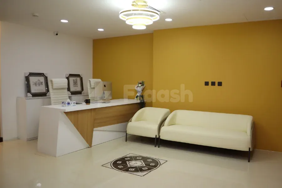 Entrance hall at Tejwaans Business Centre in Doha featuring a white reception desk with wooden paneling