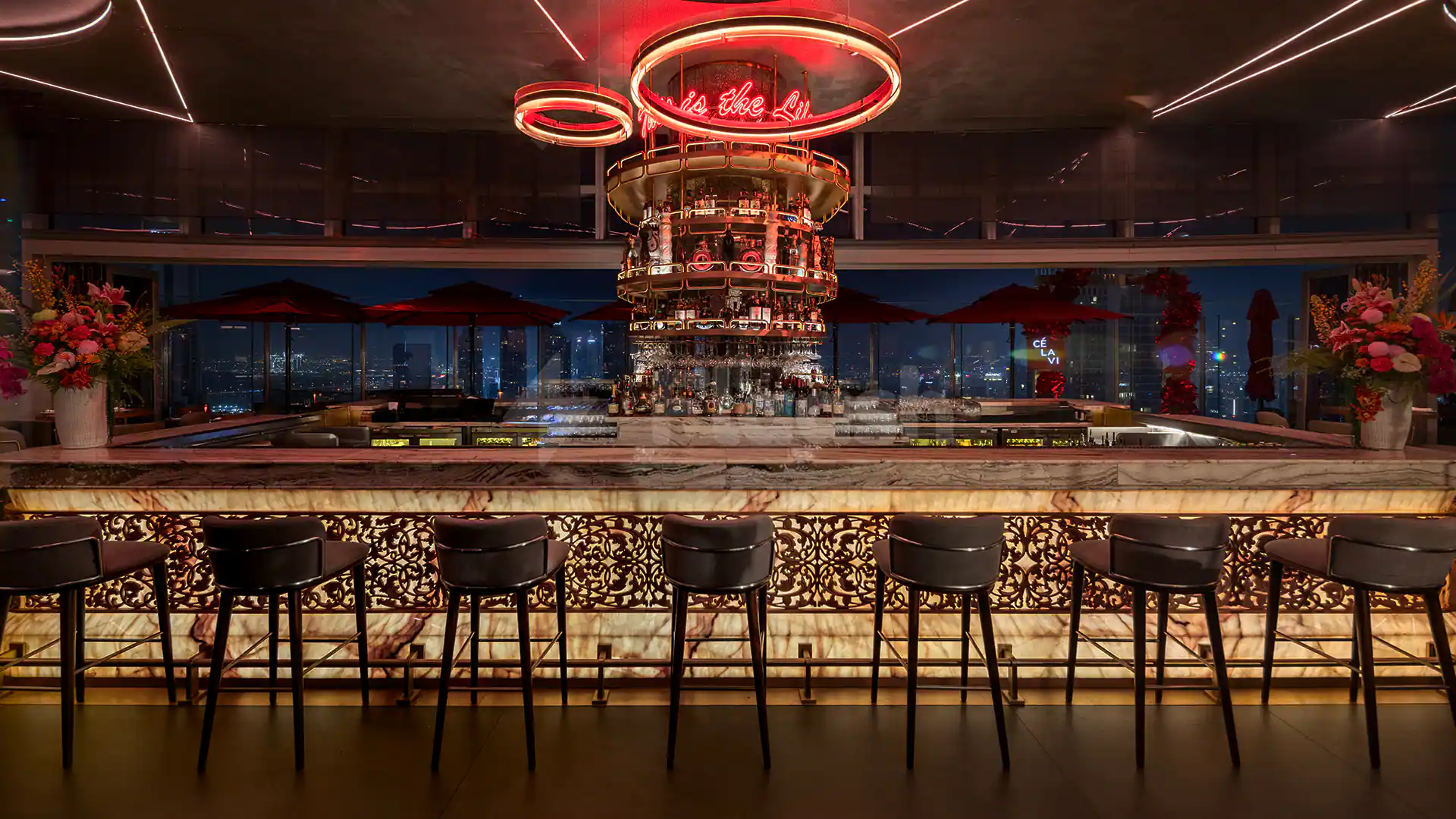 Bar counter at CÉ LA VI Dubai with multi-tiered bottle display and city night view