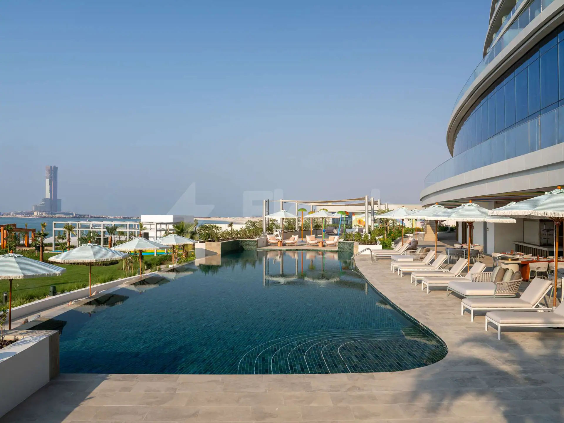 Rectangular swimming pool at SO Ras Al Khaimah Hotel & Resort in Ras Al-Khaimah with curved mosaic-tiled edge