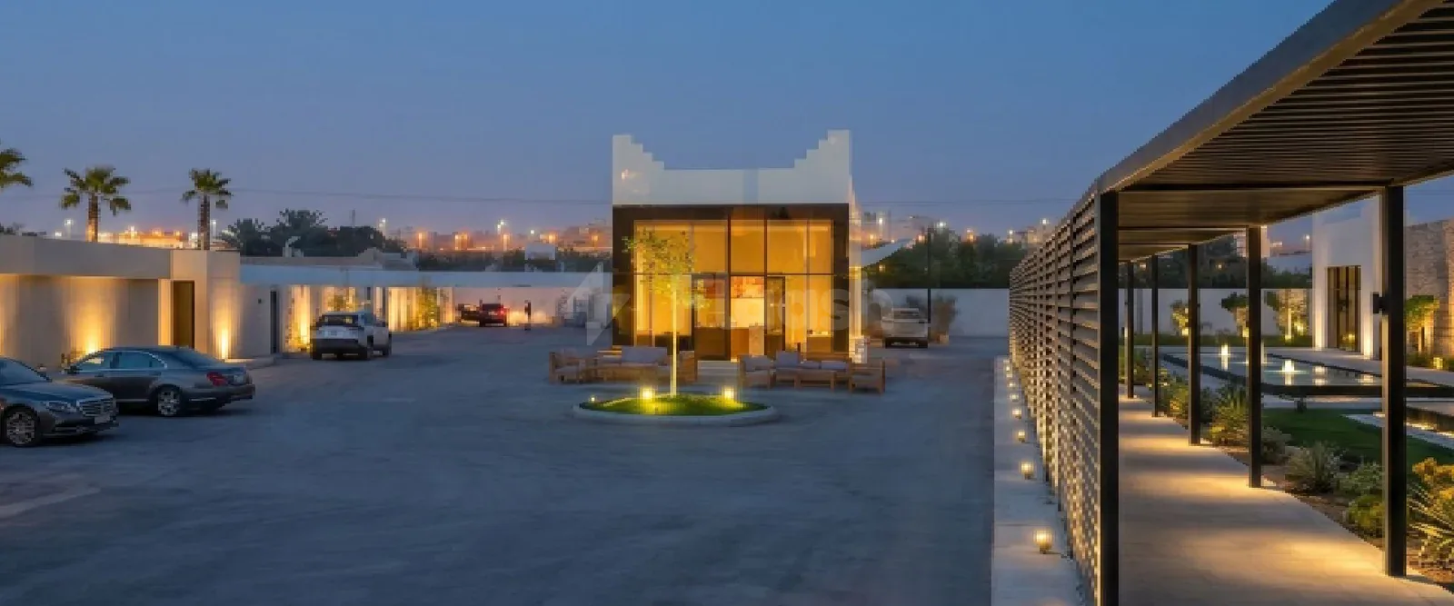 Glass-walled entrance hall at Hdb Sahafa in Riyadh with circular garden bed and warm interior lighting
