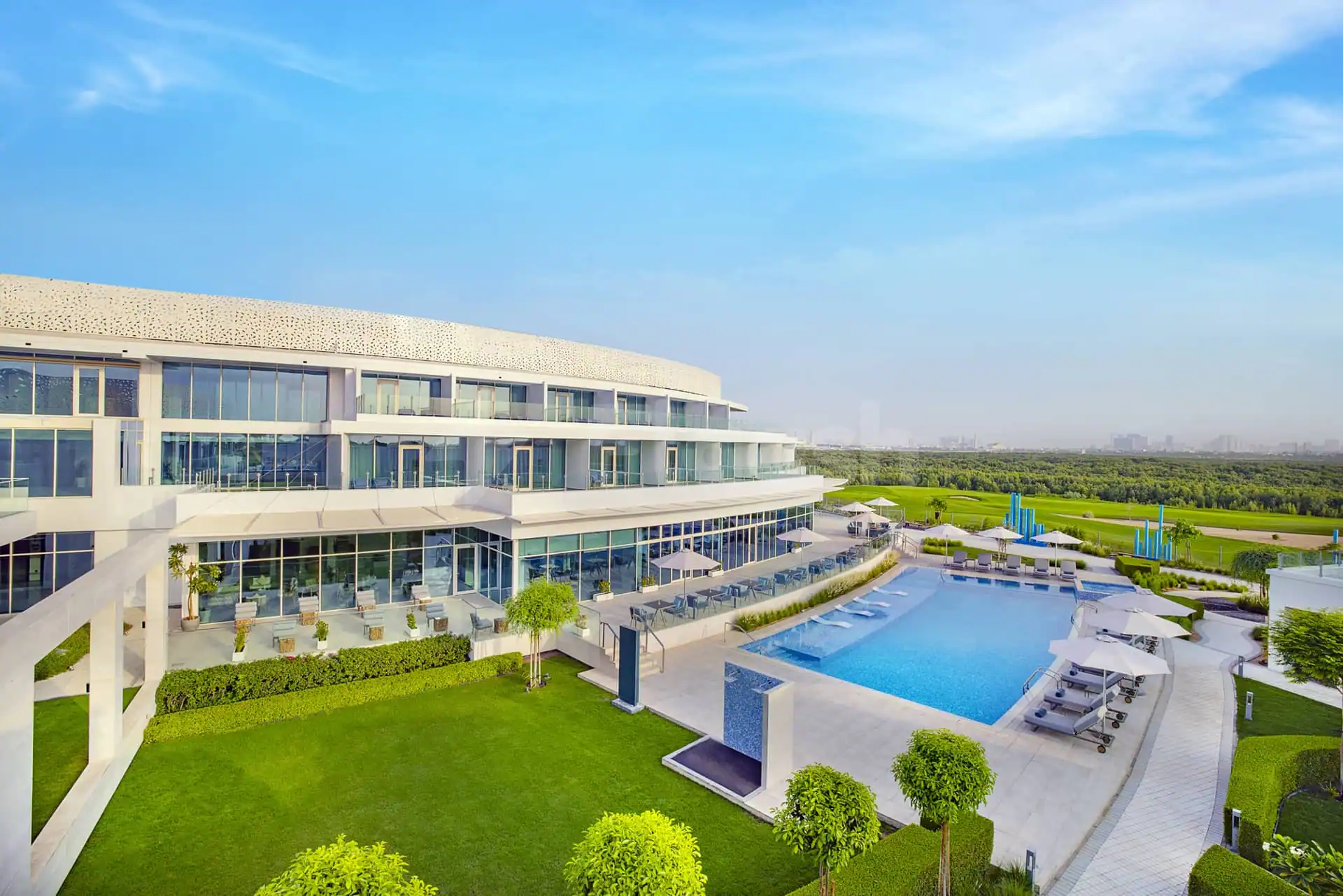 Rooftop terrace at Zoya Health & Well-Being Resort in Ajman featuring an outdoor pool and modern building with perforated