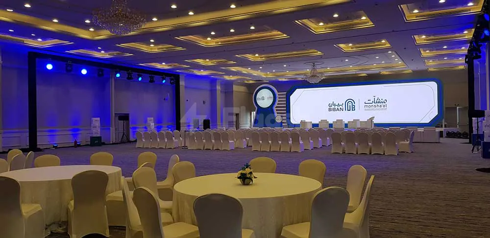Ballroom at Dhahran International Exhibition Center in Dammam featuring a stage with blue lighting and a large LED