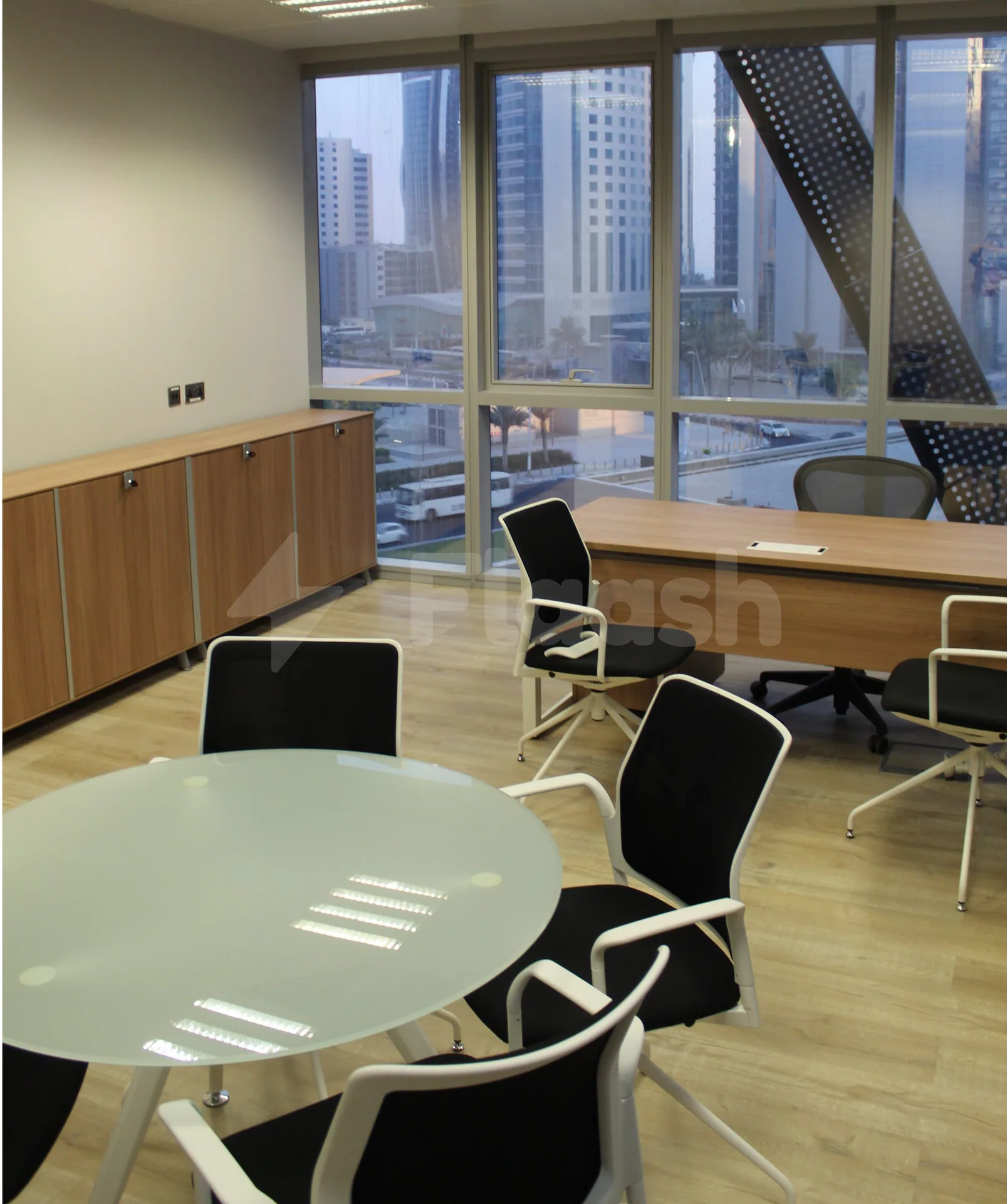 Meeting room at Workaholics Qatar in Doha with large windows overlooking the city skyline