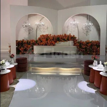 Ballroom at Hdb Sahafa in Riyadh featuring a white curved sofa, orange floral wall arrangements, and arched alcoves