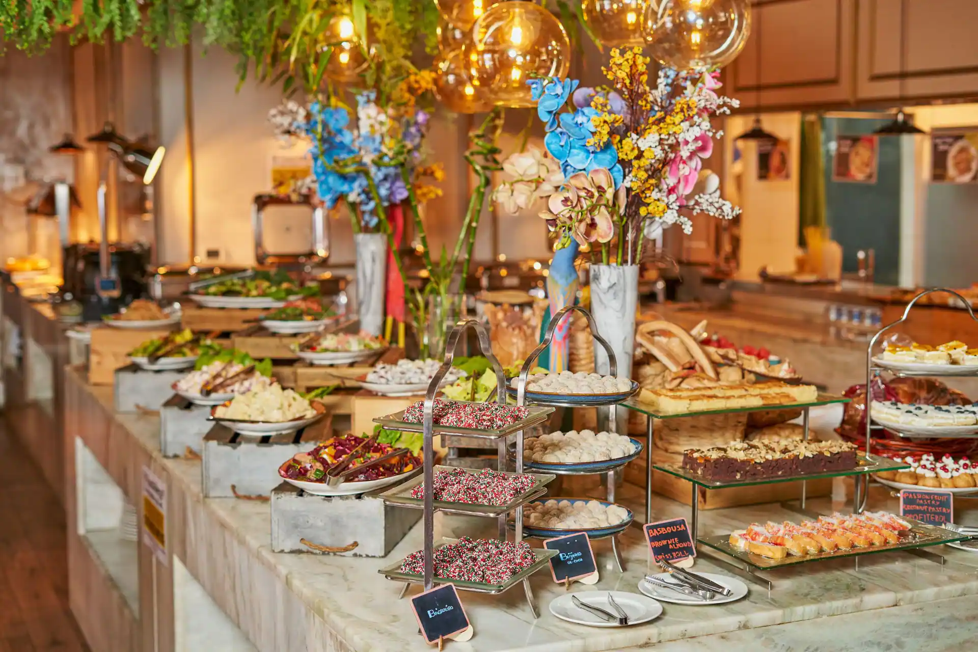 Restaurant at Al Ghazal Golf Club in Abu Dhabi featuring a marble countertop buffet with floral arrangements
