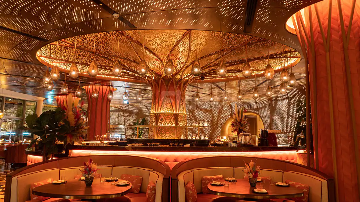 Restaurant interior at Sushisamba Lusail featuring a central ornate laser-cut column with hanging teardrop lights and curved booth