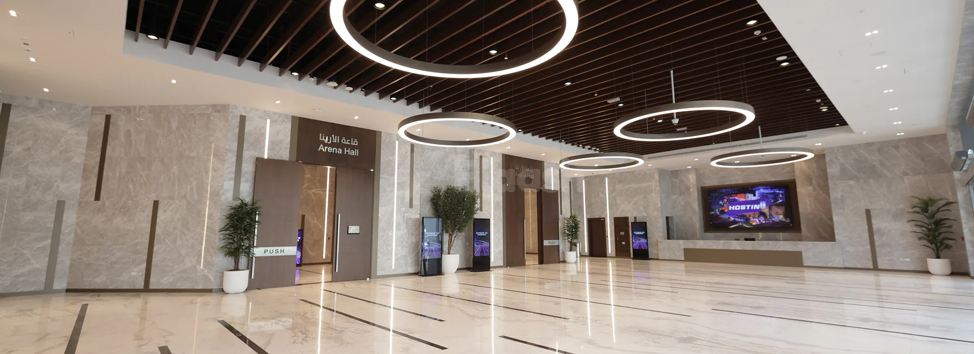 Entrance hall of Space42 Arena in Abu Dhabi featuring marble floors, grey marble walls, and circular pendant lights