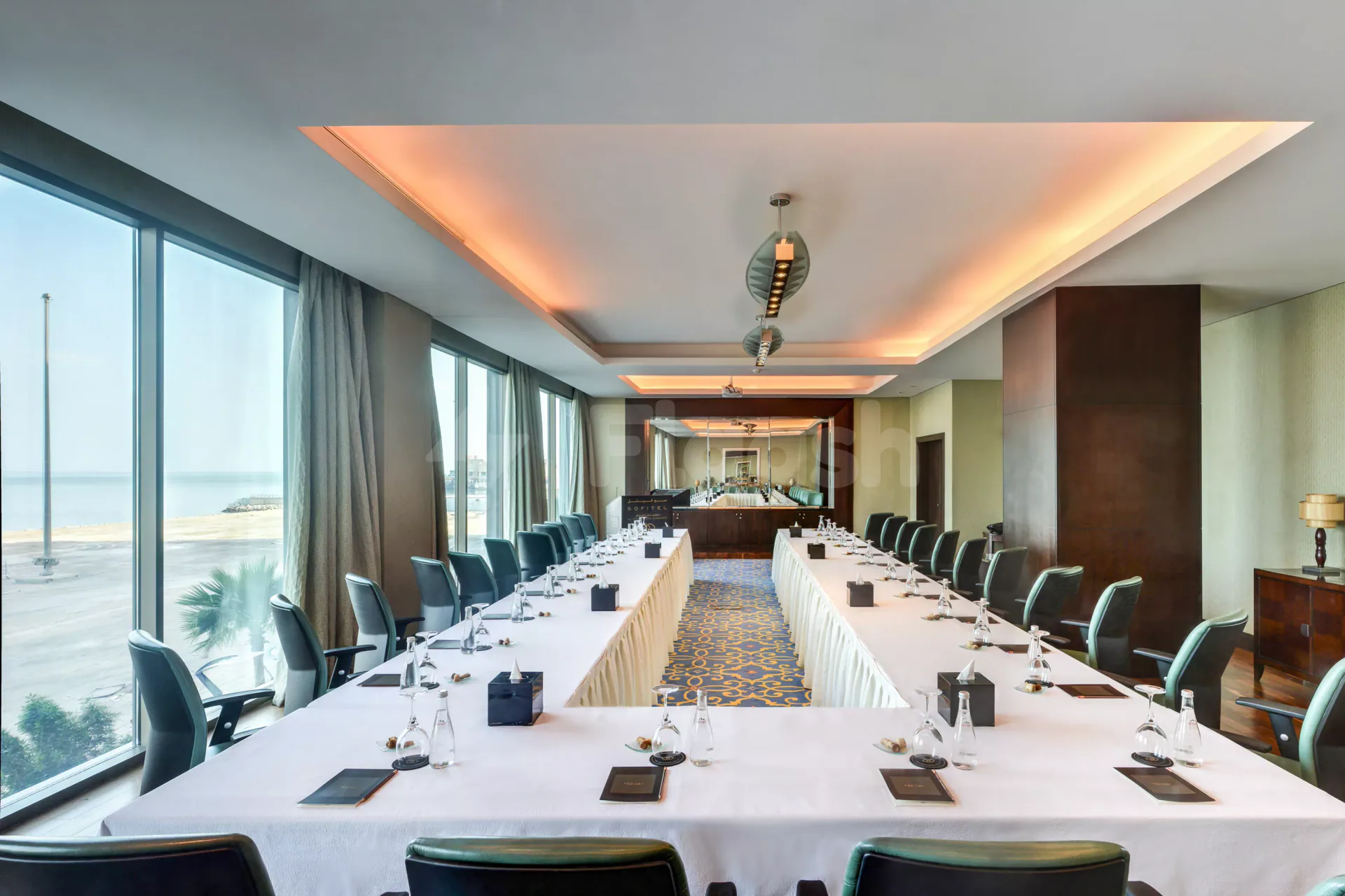 Boardroom at Sofitel Al Khobar The Corniche with long rectangular tables, white tablecloths, and floor-to-ceiling windows overlooking