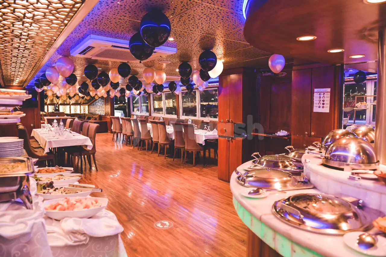 Dining area at Royal Yacht Restaurant in Abu Dhabi with patterned ceiling and balloon decorations