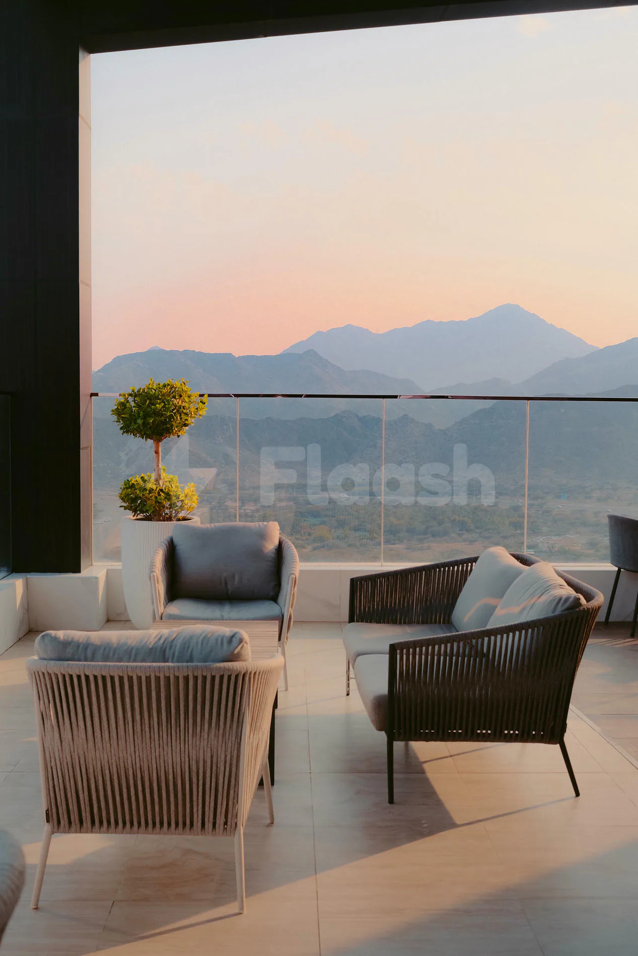 Rooftop terrace at Royal M Hotel & Resort Al Aqah Beach Fujairah featuring modern wicker seating, glass railing