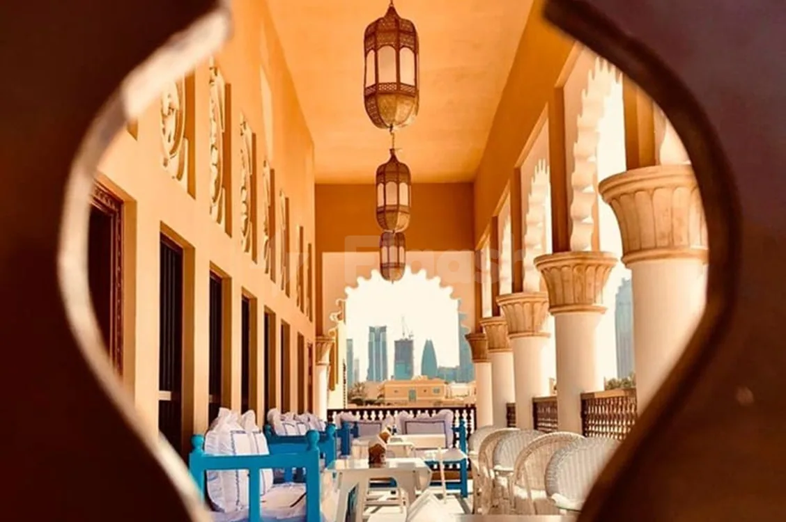 Rooftop terrace at Arabian Tea House Restaurant & Cafe Sharjah featuring hanging ornate lanterns and arched stone columns