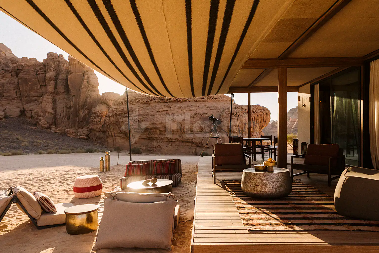 Terrace at Tama At Habitas AlUla featuring a striped fabric canopy and wooden deck overlooking desert rock formations