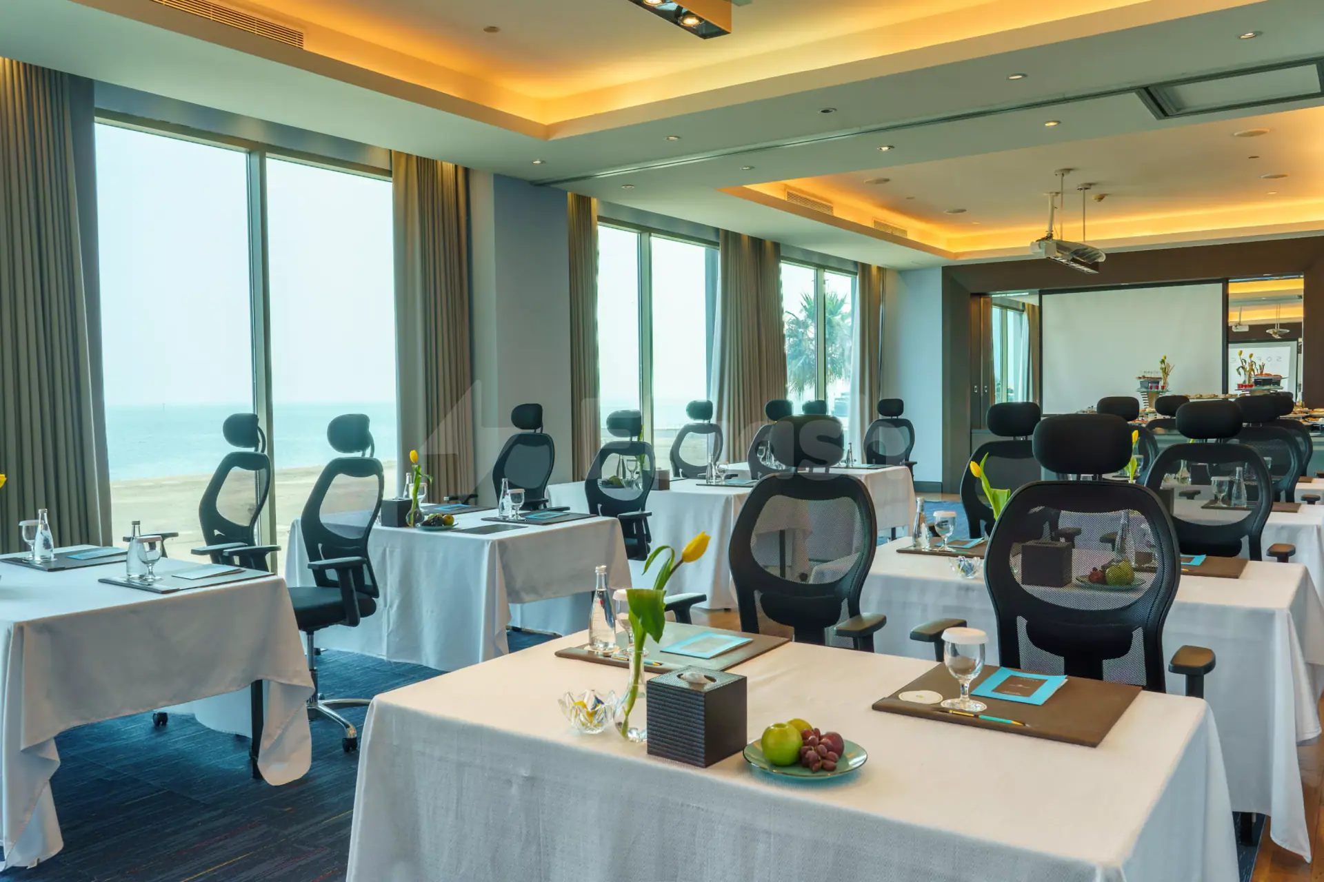 Meeting room at Sofitel Al Khobar The Corniche with sea views through large windows and black mesh chairs