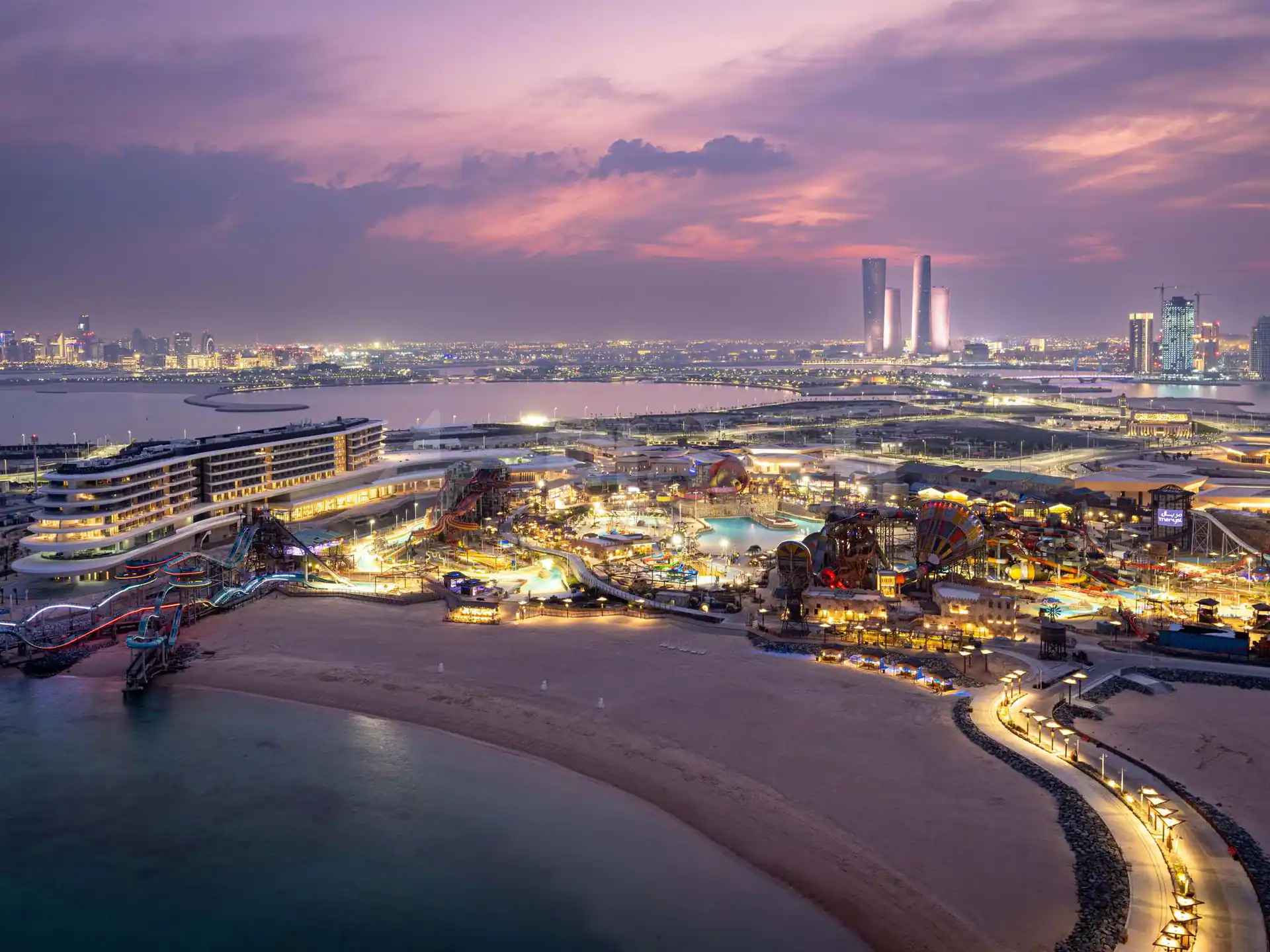 Rooftop terrace at Rixos Premium Qetaifan Island North in Doha overlooking illuminated water park slides and city skyline