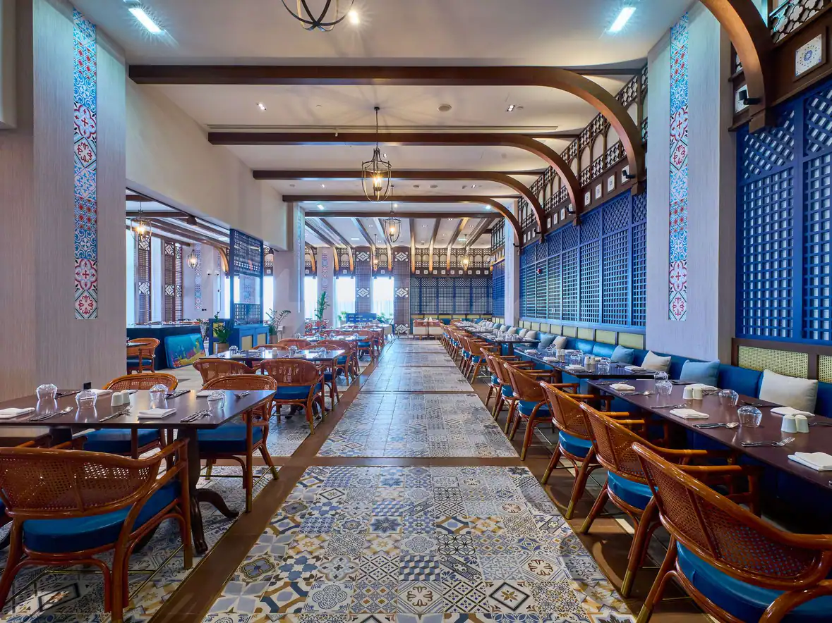 Long dining room at Rixos Premium Qetaifan Island North in Doha featuring patterned tile flooring and blue lattice
