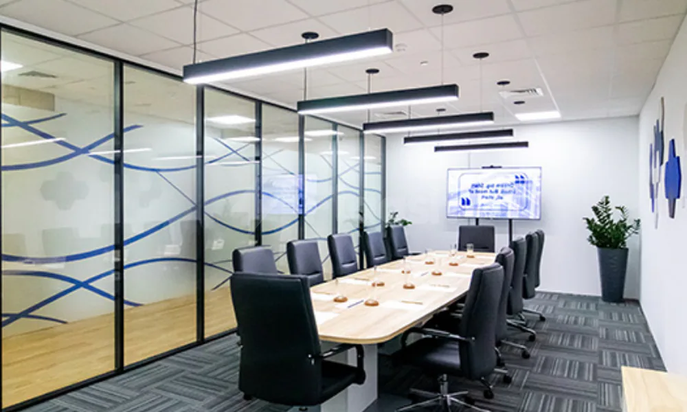 Boardroom at Hub Business Center Burj Marina Lusail featuring glass partition walls with blue wave patterns and suspended