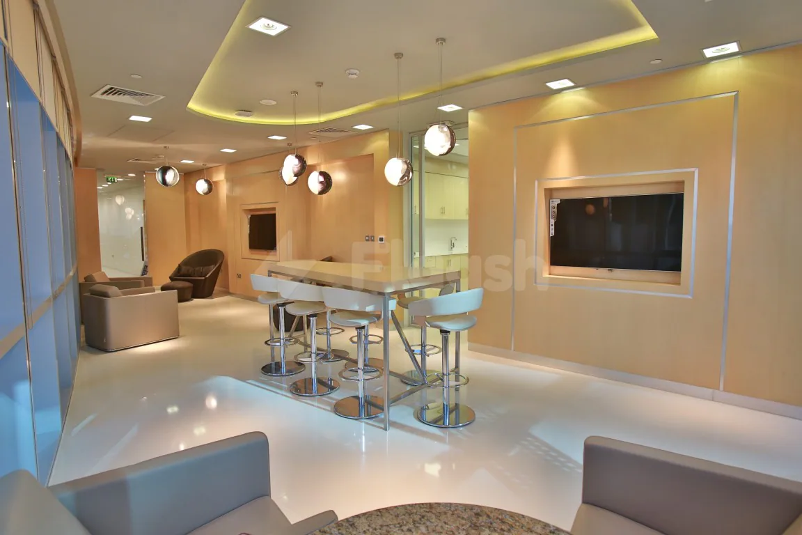 Restaurant at Globex Business Centre Doha featuring a bar counter with white stools and spherical pendant lights under