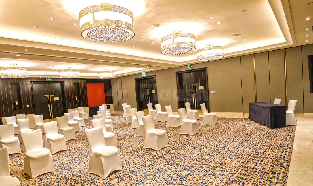 Meeting room at Namak Restaurant Abu Dhabi with white chair covers arranged on a patterned carpet under ornate