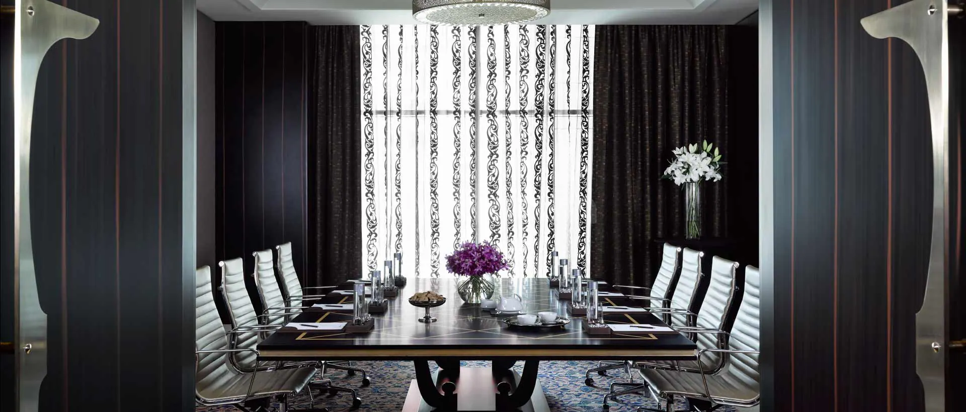 Boardroom at Namak Restaurant Abu Dhabi featuring a long black table with gold inlay and white leather chairs
