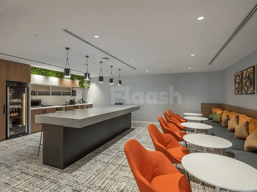 Restaurant at Gravita Coworking Space Jeddah featuring an open kitchen with a white countertop and green living wall