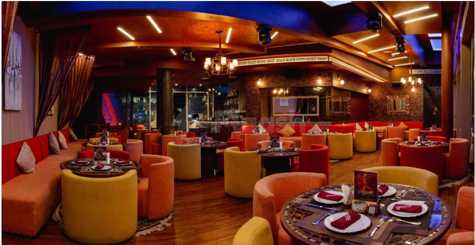 Restaurant interior at Ornina Arabian Lounge in Abu Dhabi with circular ottoman-style seating and ambient lighting