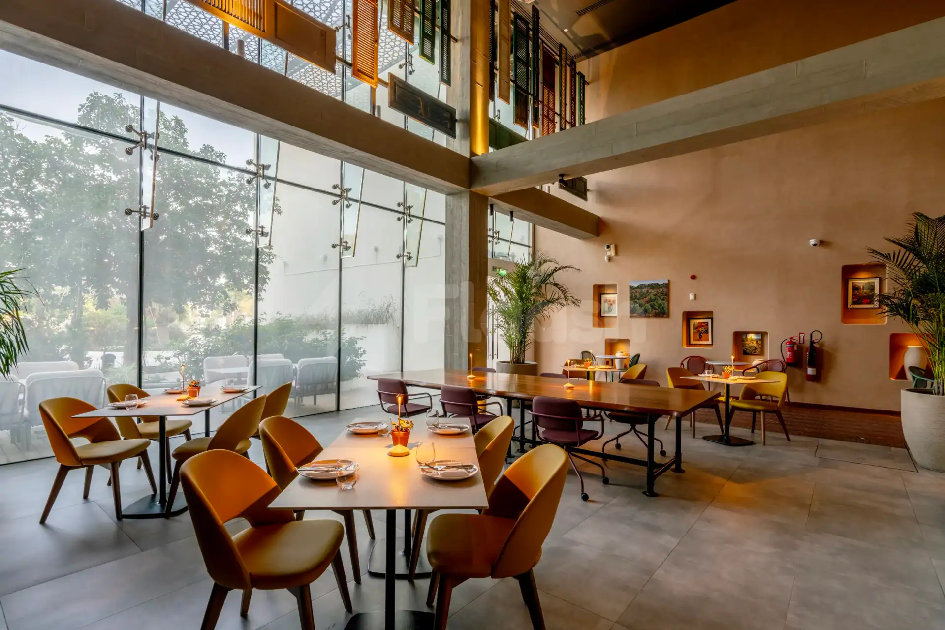 Taparelle Restaurant in Abu Dhabi features a modern dining space with large glass windows and exposed concrete beams
