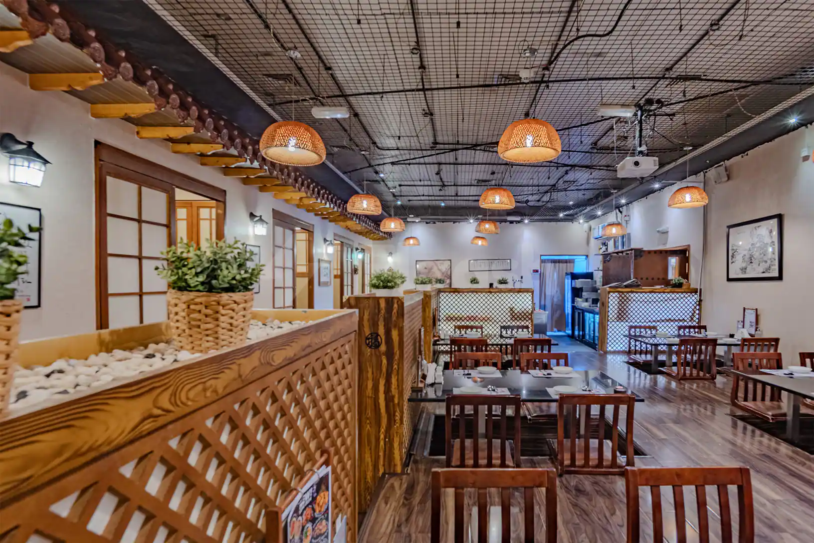 Restaurant at Al Ghazal Golf Club in Abu Dhabi featuring woven pendant lights and wooden lattice partitions