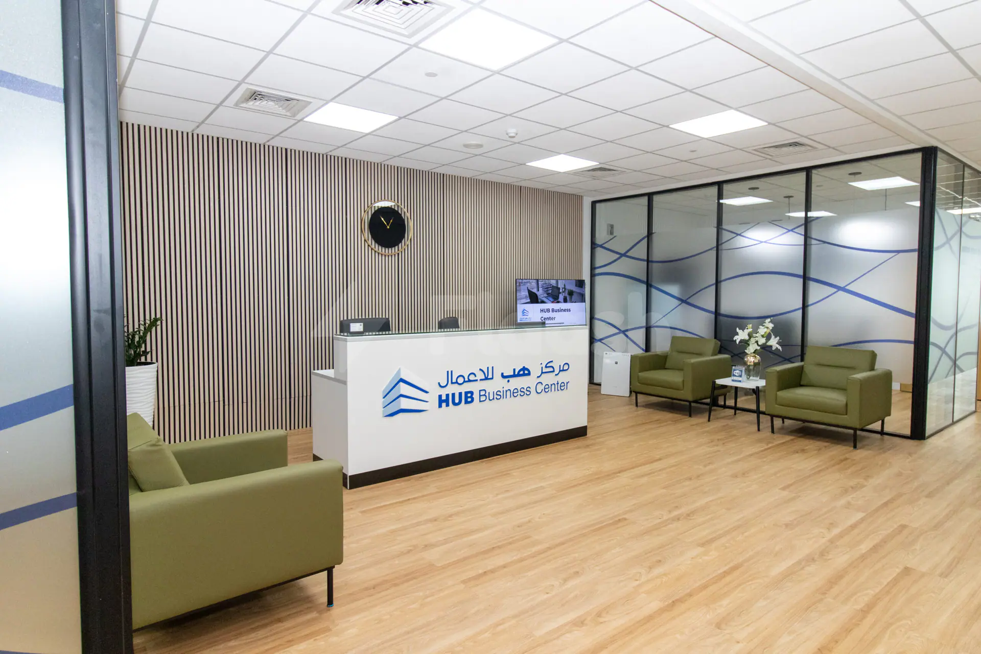 Reception desk at Hub Business Center Burj Marina Lusail featuring striped wall paneling and glass partitions with blue