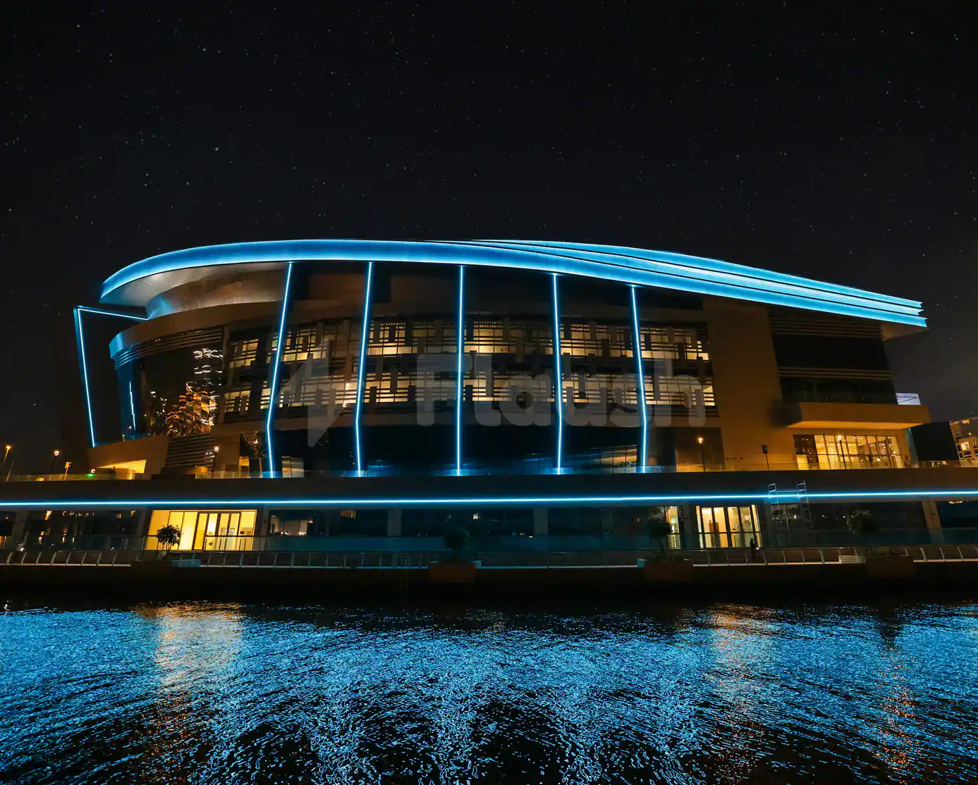Space42 Arena facade in Abu Dhabi at night, featuring a curved modern design with blue LED lighting
