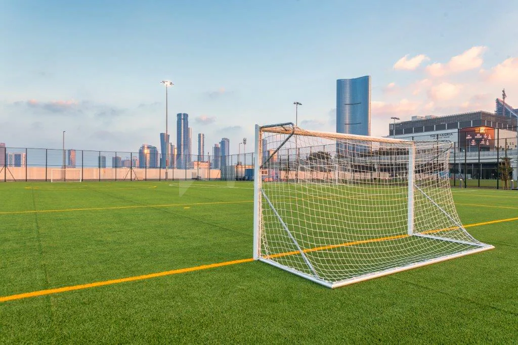 Rooftop artificial grass field at Active Al Maryah Island Sports & Recreation in Abu Dhabi with city skyline backdrop