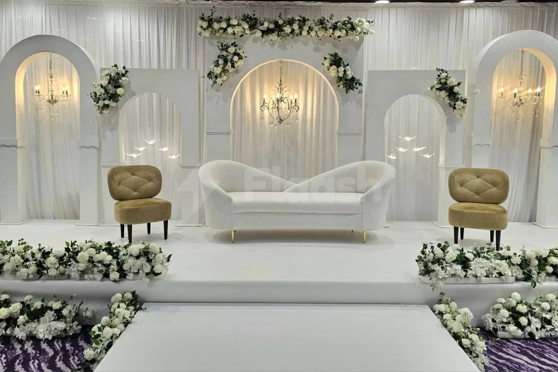 Ballroom at Time Rako Hotel Qatar in Doha with white arched backdrop and floral garlands