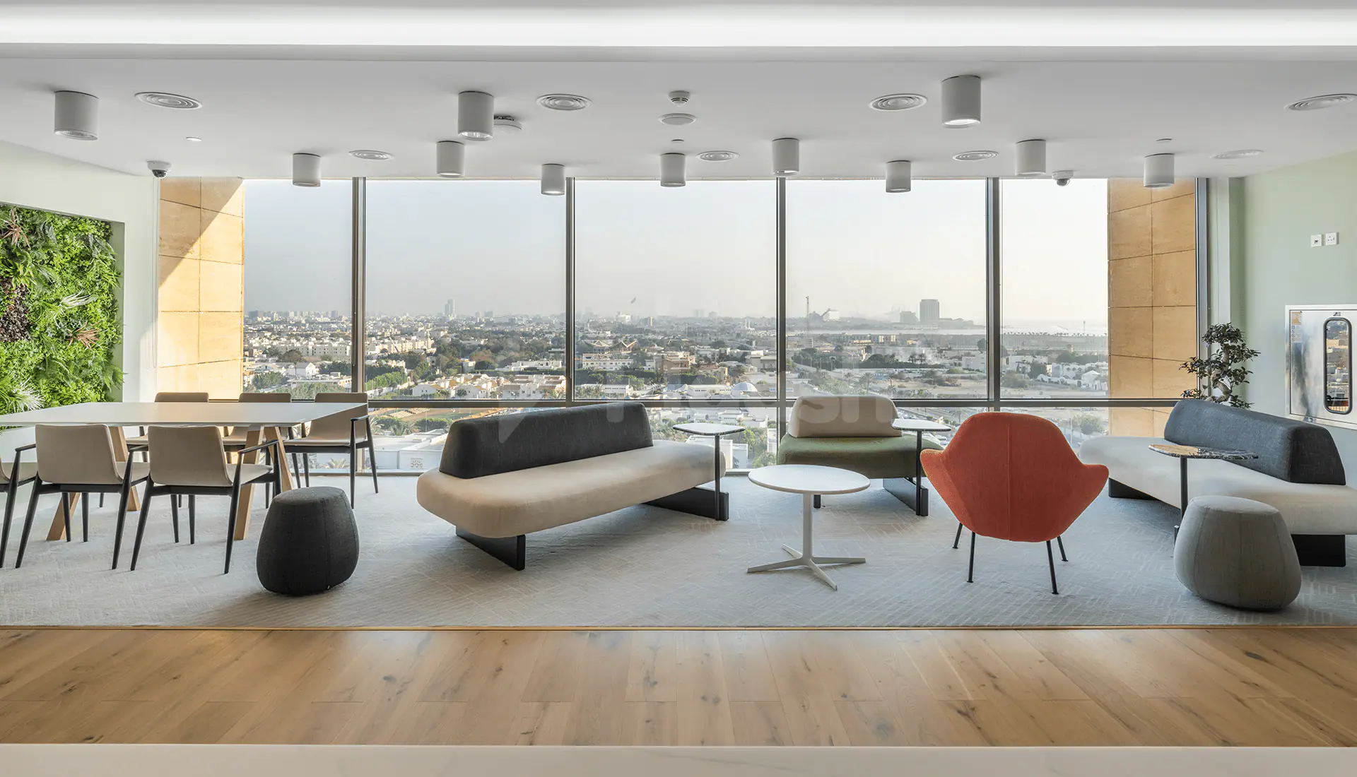 Meeting room at Gravita Coworking Space Jeddah featuring floor-to-ceiling windows with city views and a green living