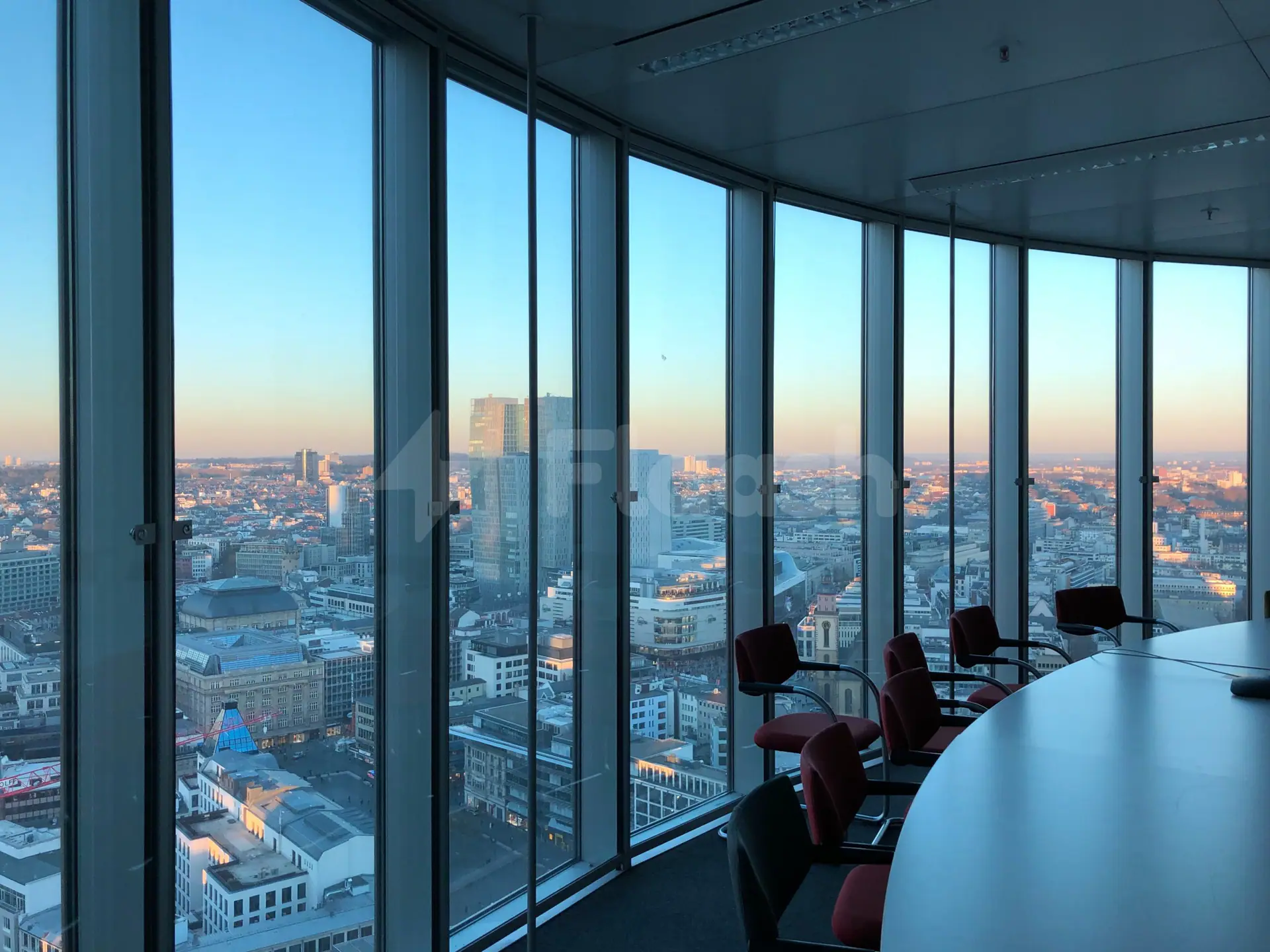 Boardroom at Workaholics Qatar in Doha featuring floor-to-ceiling glass windows overlooking the city skyline during twilight