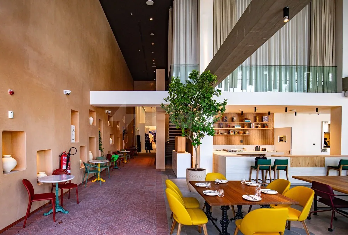 Taparelle Restaurant in Abu Dhabi features a modern dining space with an indoor tree and terracotta walls
