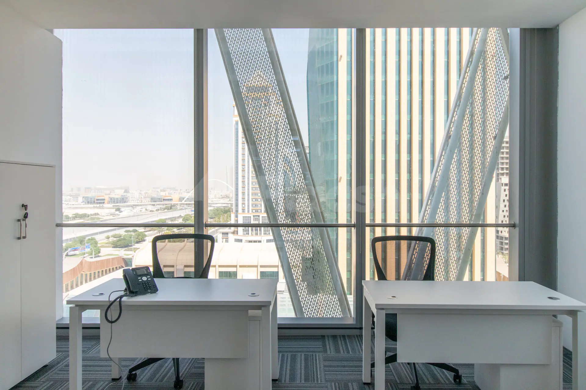 Meeting room at Hub Business Center Burj Marina Lusail with large windows, perforated metal screens, and city view
