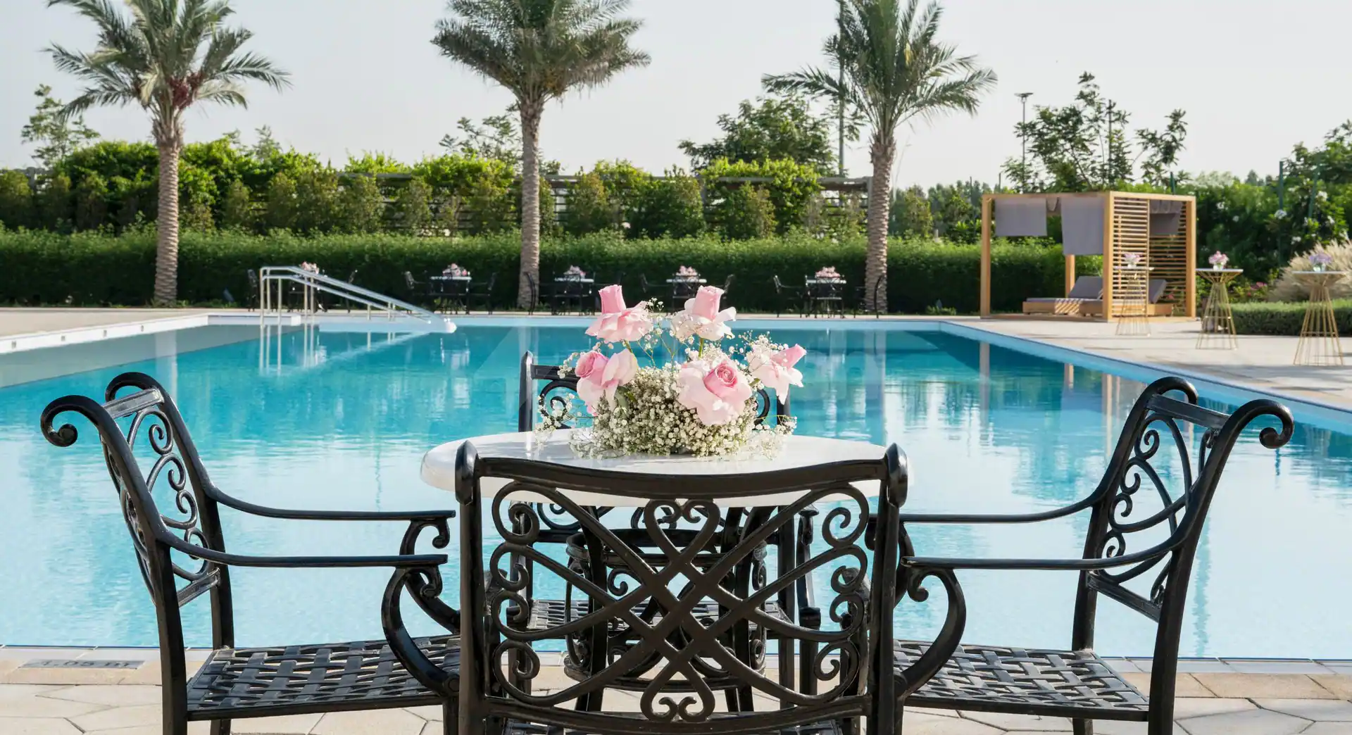 Rectangular swimming pool at Yas Acres Golf & Country Club in Abu Dhabi with pink rose centerpiece on patio