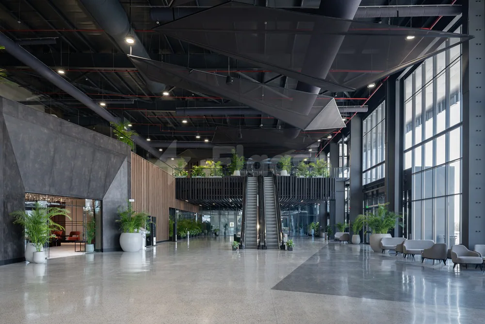 Entrance hall at Dhahran International Exhibition Center in Dammam with black geometric ceiling panels and escalator