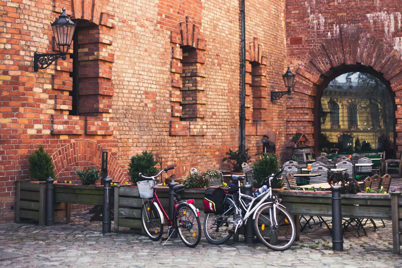 Terrace at Hoods Resto & Bar in Abu Dhabi featuring a red brick wall, arched doorway, cobblestone floor